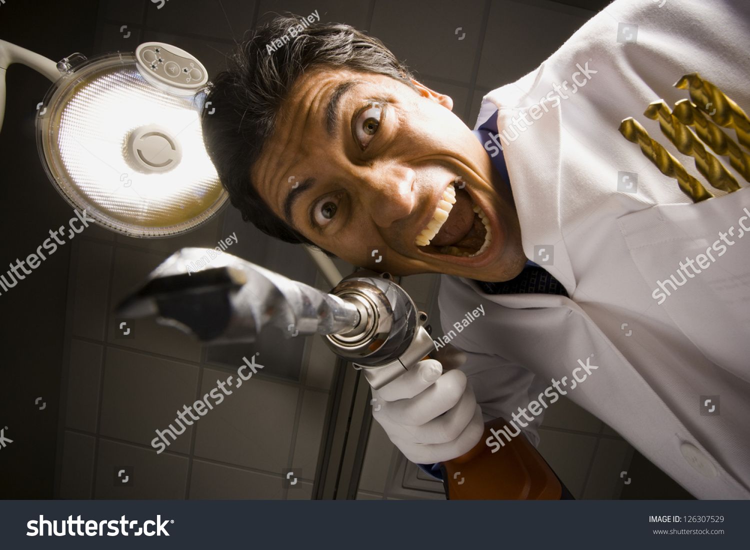 stock-photo-portrait-of-crazy-dentist-with-drill-126307529.jpg