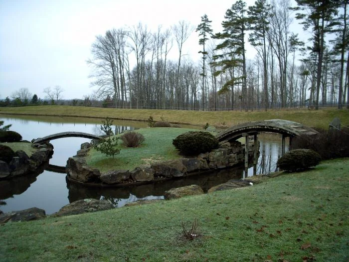 Close image of two arc bridges connecting 2 of the three islands on the pond. Sadly, there is no access to the islands.